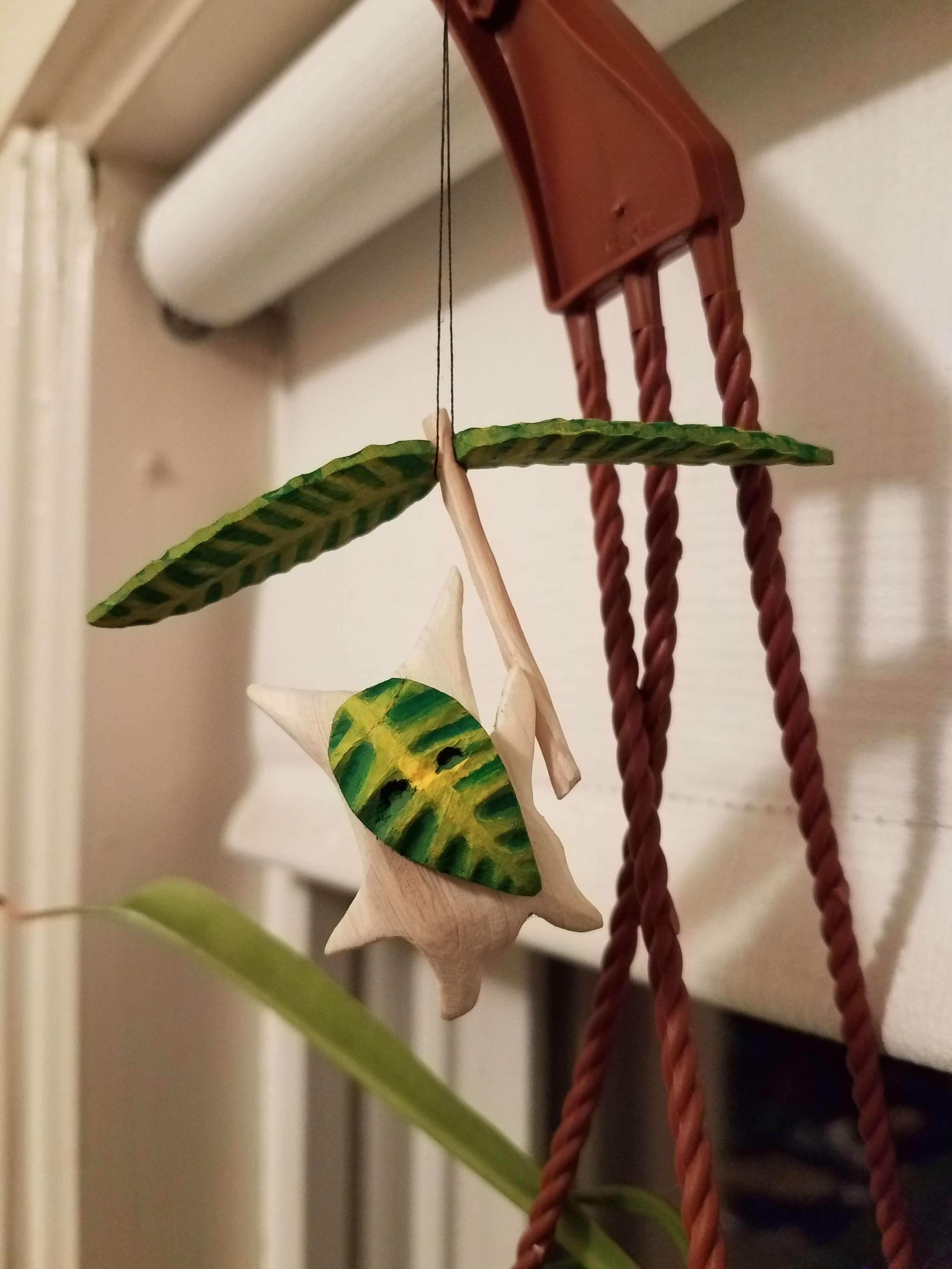 the flying propeller korok dangling from a thread over a hanging, potted spiderplant